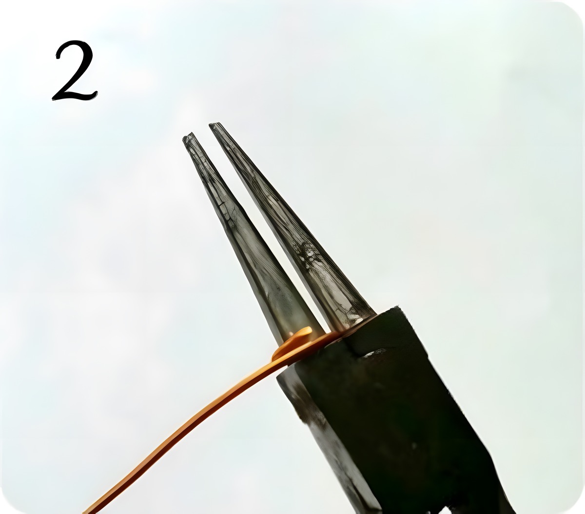 Starting to coil copper craft wire around the large barrel of round-nose pliers