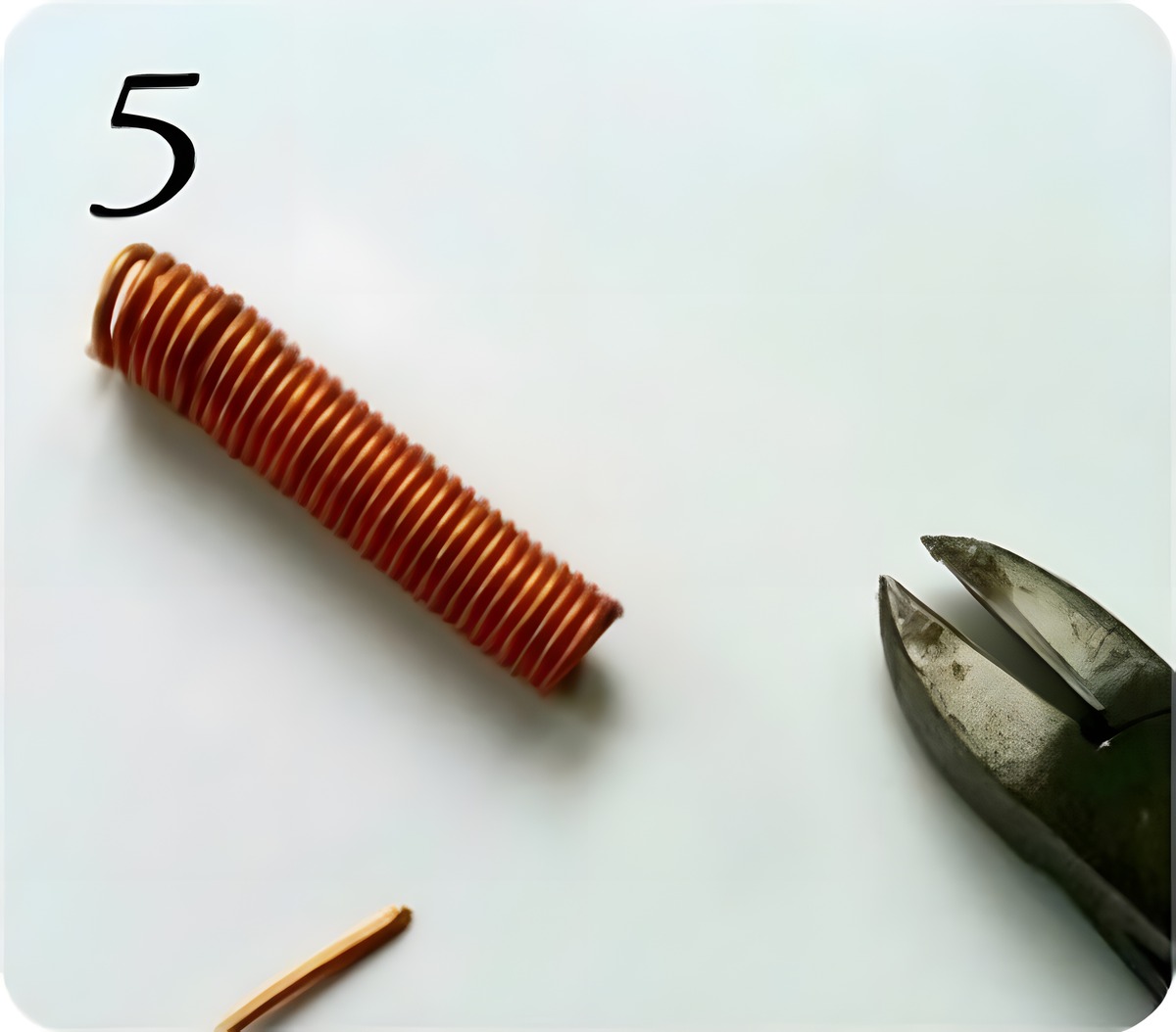 Cutting the completed copper wire coil free from the bundle using cutting pliers