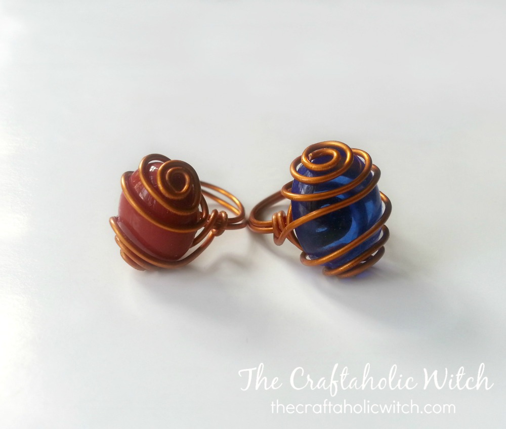 Finished caged gemstone ring with an oval stone wrapped in wire swirls