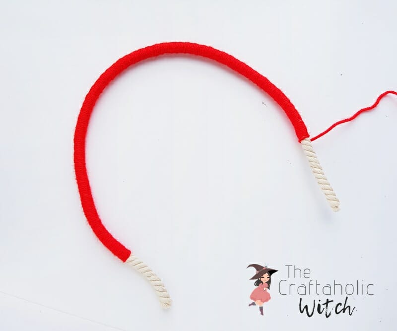 Macrame Rainbow Step 3: Finish the Yarn Wrapping Macrame rainbow wall hanging step 3: finished yarn-wrapped rope with cotton tassel ends