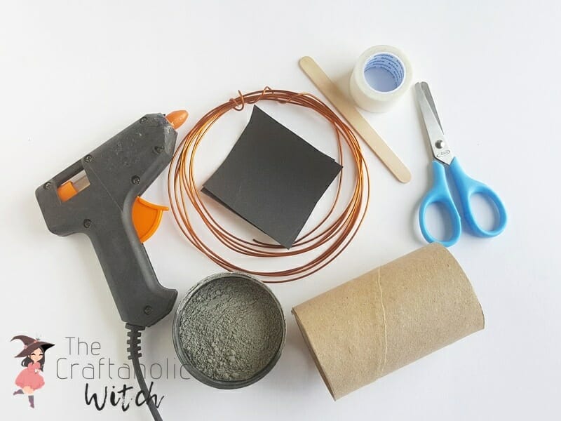 Supplies for a wire picture holder including concrete mix, craft wire, cardstock, toilet paper roll, and tools