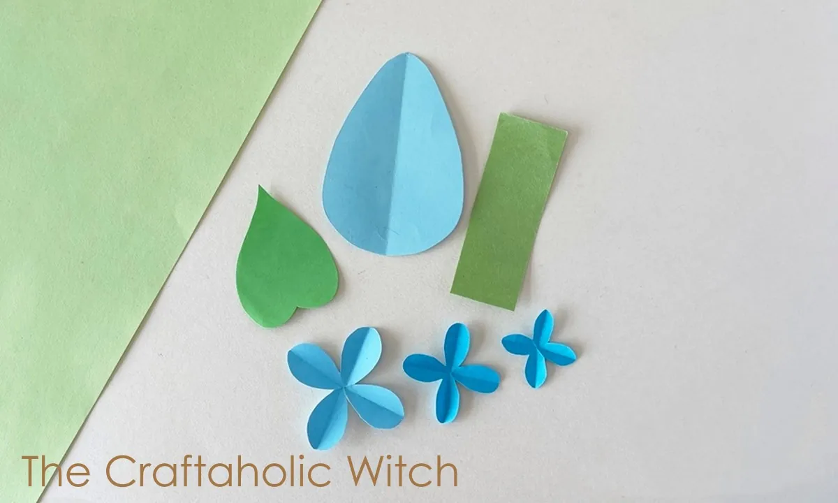 Paper lilac flower craft step 1 Template-cut paper lilac flower pieces including petals, leaf, and stem parts