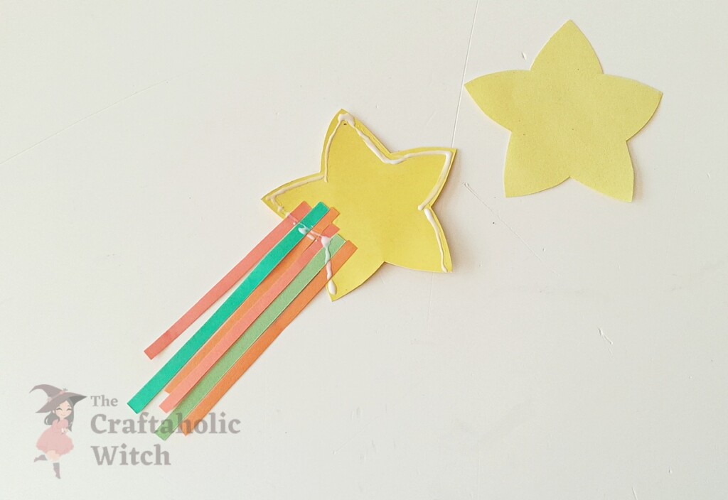 Glue applied around perimeter of paper star leaving opening for pencil on DIY topper