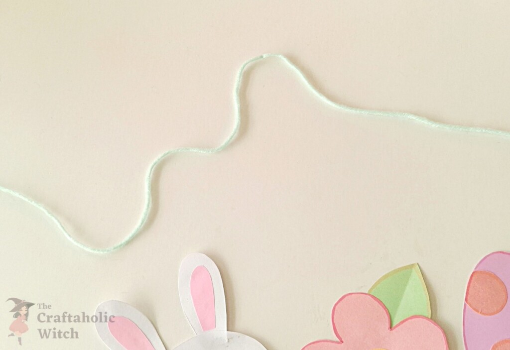 Long piece of yarn cut and laid out ready for the paper garland