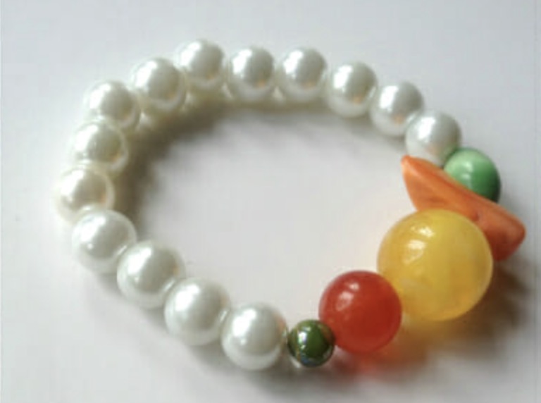 Mixed beaded bracelet beads sorted into small color combinations before stringing