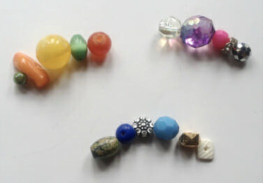 Tying a double knot to close the elastic on a mixed beaded bracelet