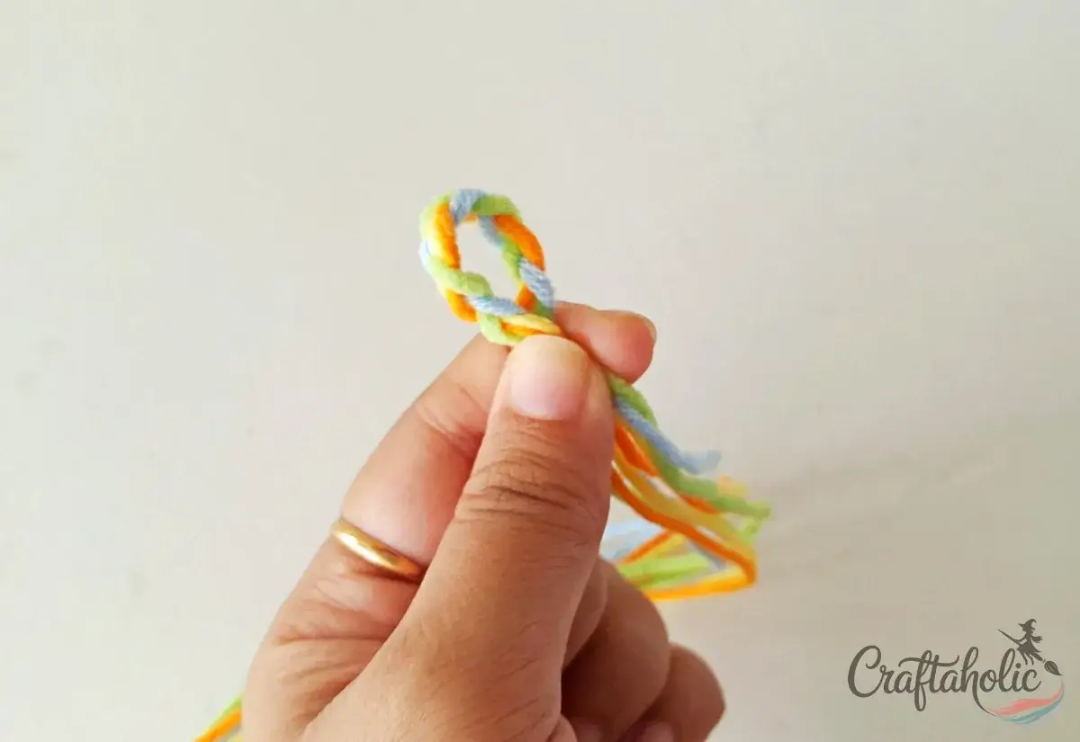 Holding the braided middle to form a closure loop for the bracelet