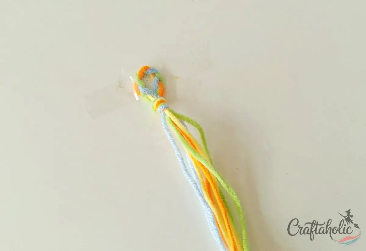 Taping the braided loop to a flat surface to start the four-strand braid