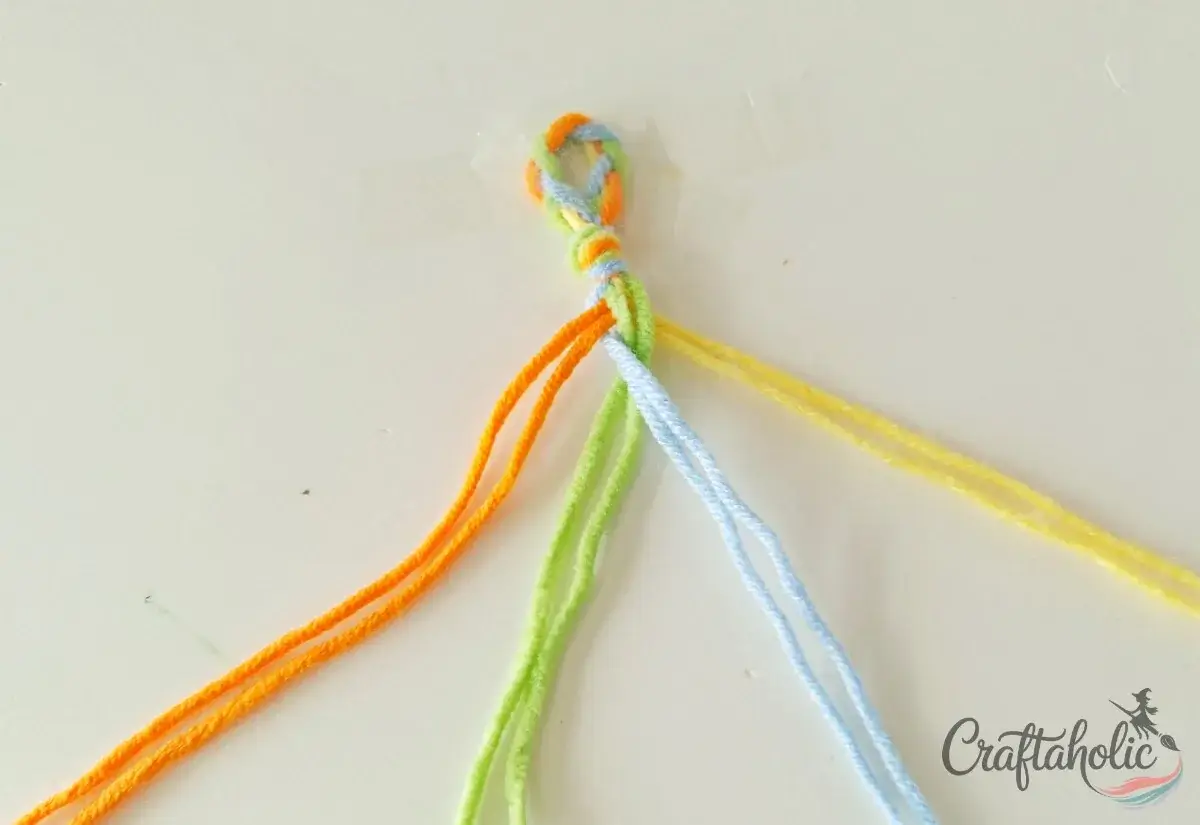 Drawing the middle strands over each other in the four-strand braid