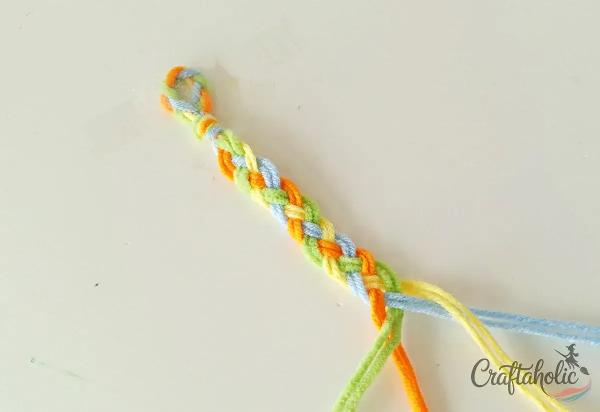Repeating the four-strand braid pattern down the friendship bracelet