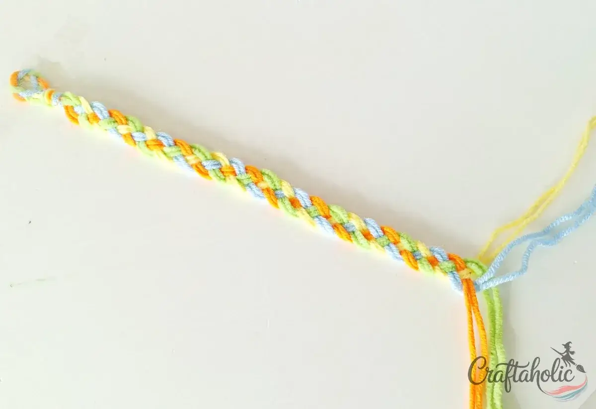 Braiding the friendship bracelet to the required wrist length