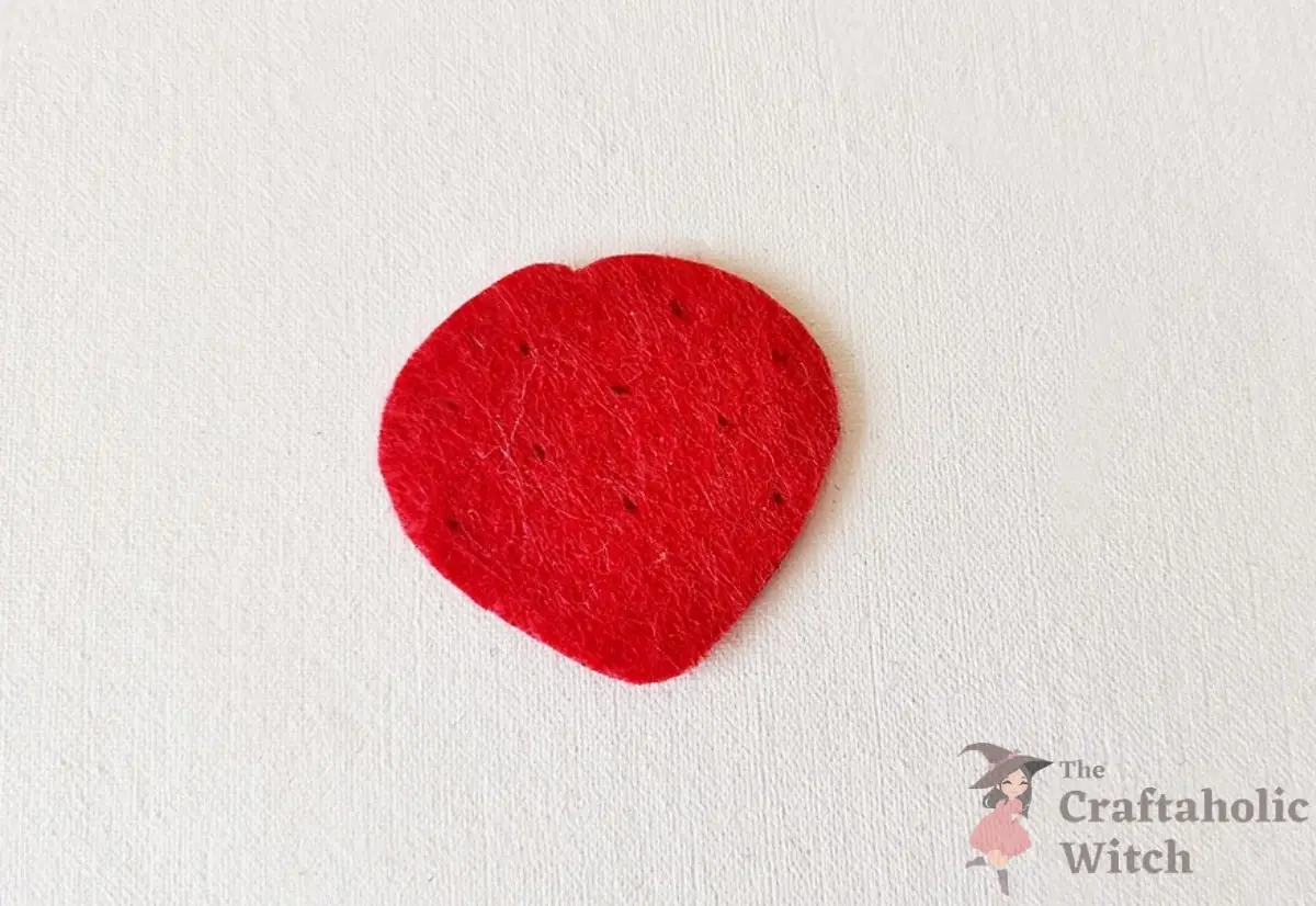 Marked strawberry felt piece prepared for seed stitching