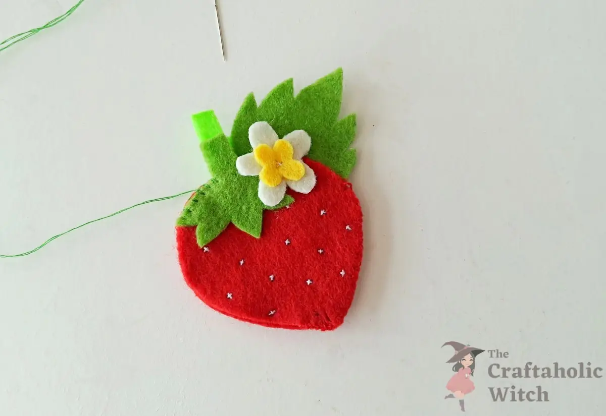 Felt loop strip positioned at the top of the strawberry before edge stitching
