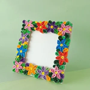 Finished paper quilling photo frame decorated with colorful quilled flowers standing upright