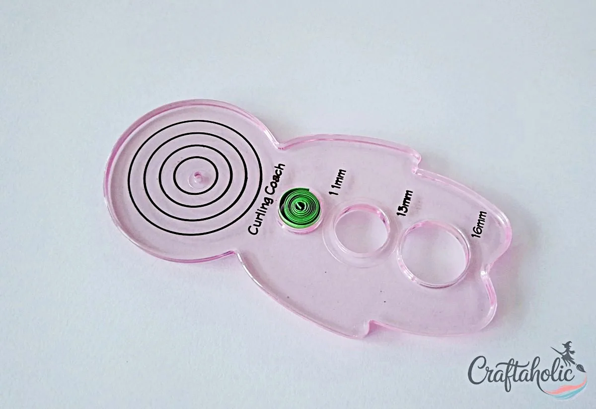 Coil green strip for leaves Coiling a green quilling strip and placing it in a round shape ruler