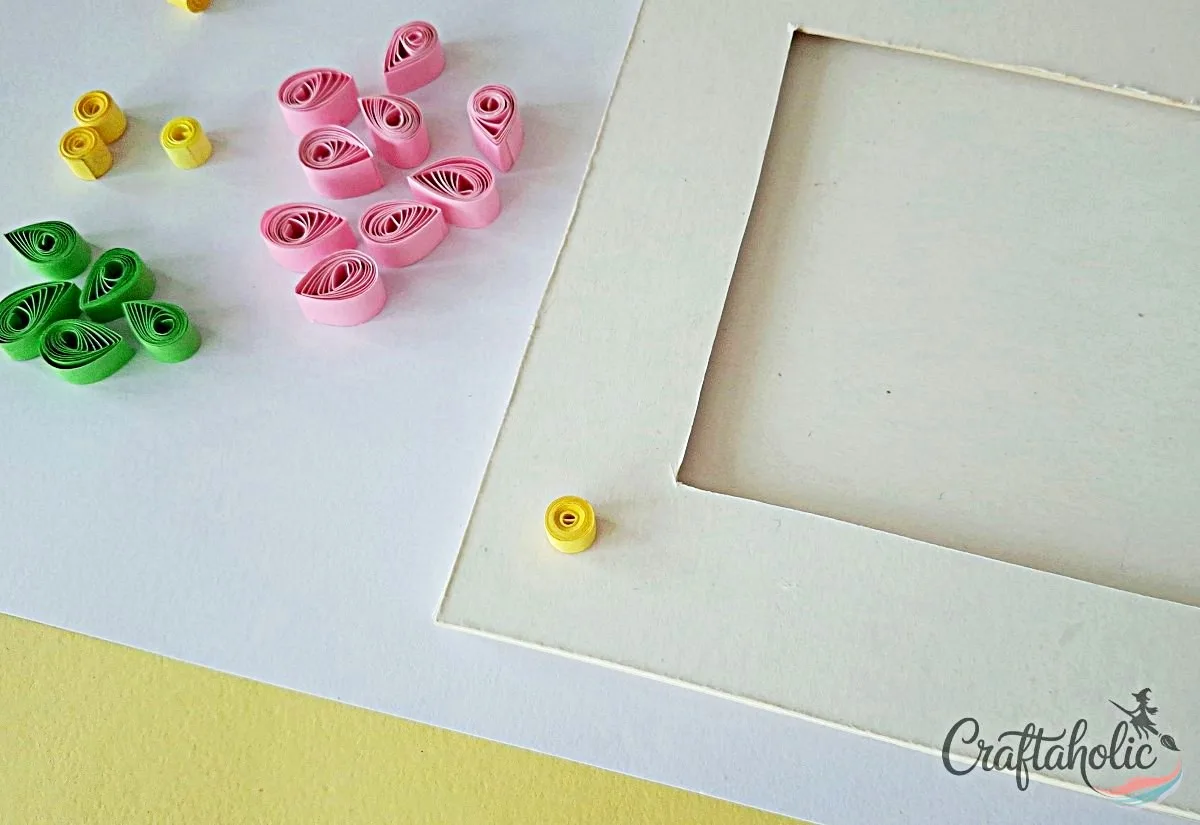 Start decorating the frame Placing a loose coil on the frame to start decorating with quilled flowers