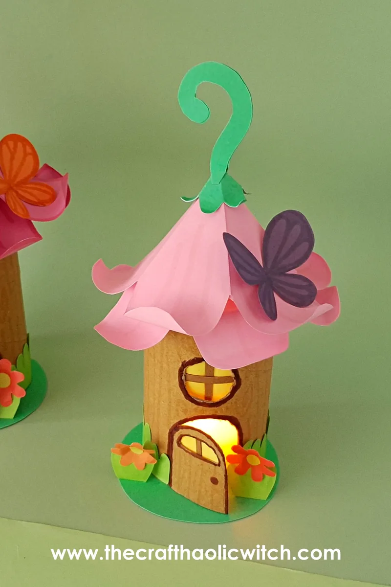 Toilet paper roll fairy house lantern glowing warmly with LED candle light