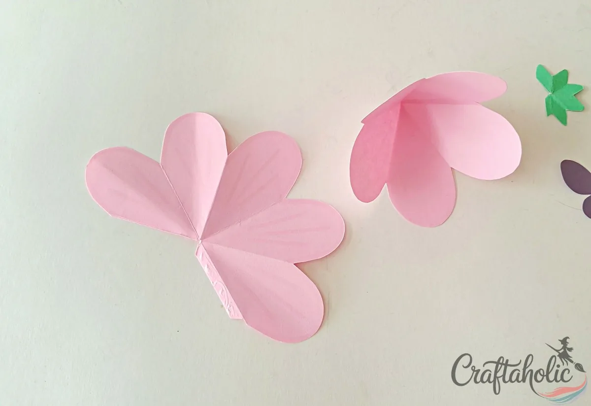 Gluing paper flower petals into a 3D flower roof shape for the fairy house