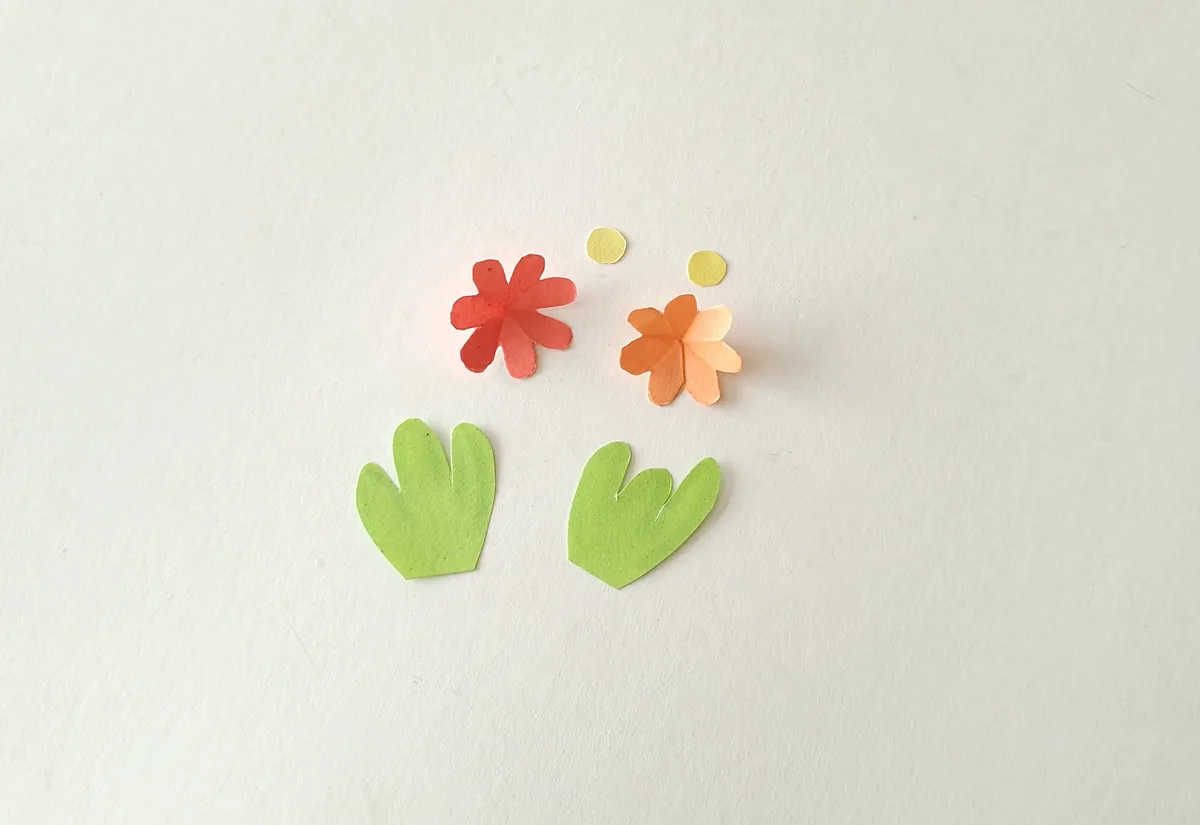 Cutting a small slit between the petals of the small paper flowers