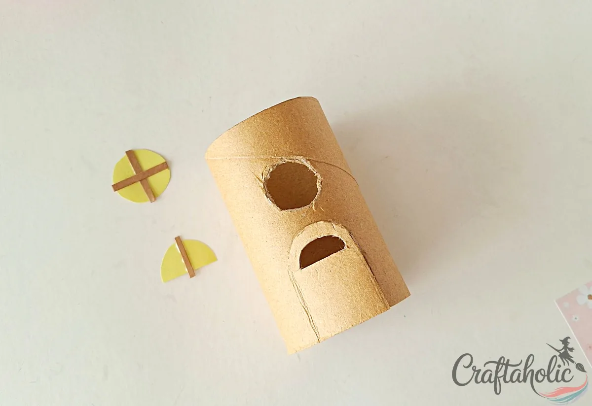 Cutting the door and window on the toilet paper roll with an x-acto knife