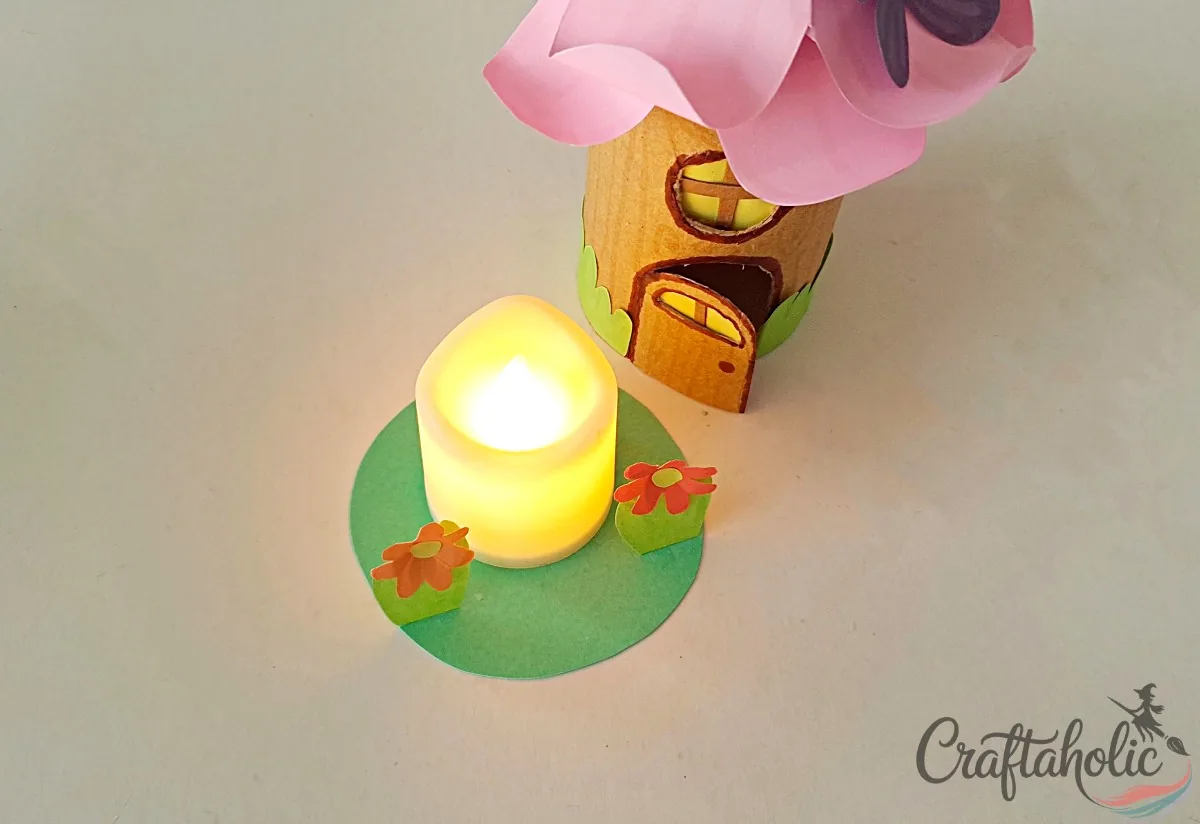 Placing a small LED candle in the center of the fairy house base