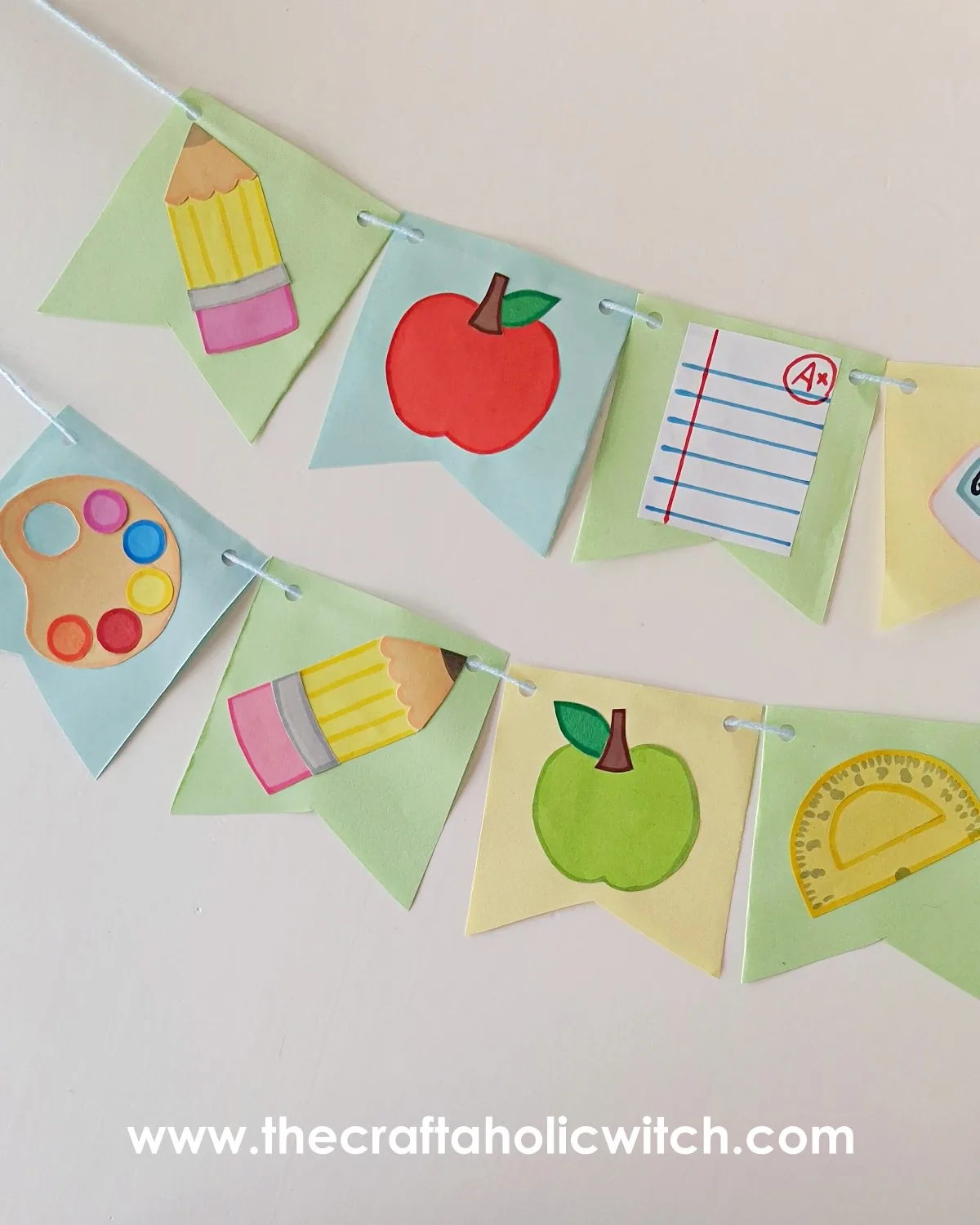 Back to school paper garland strung on twine Finished back to school paper garland with painted school-themed bunting flags strung on twine