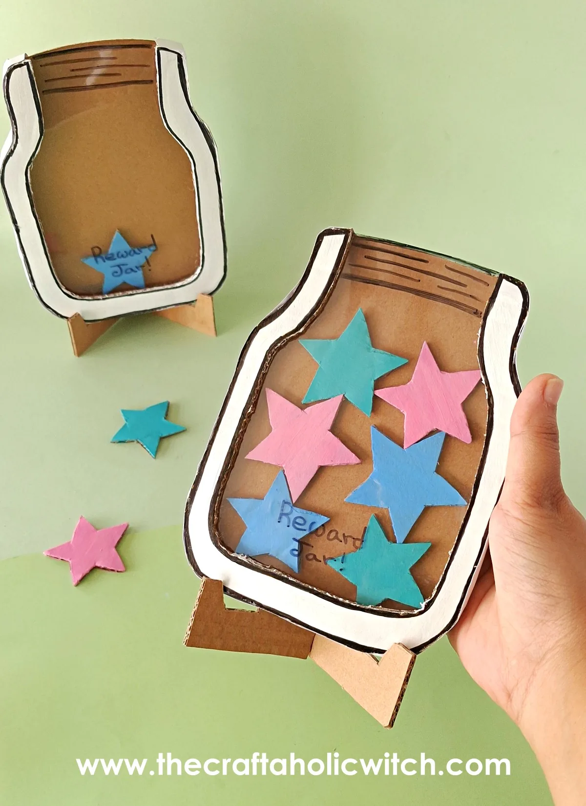 Adding a star to the finished classroom reward jar Dropping a painted cardboard star into the classroom reward jar craft