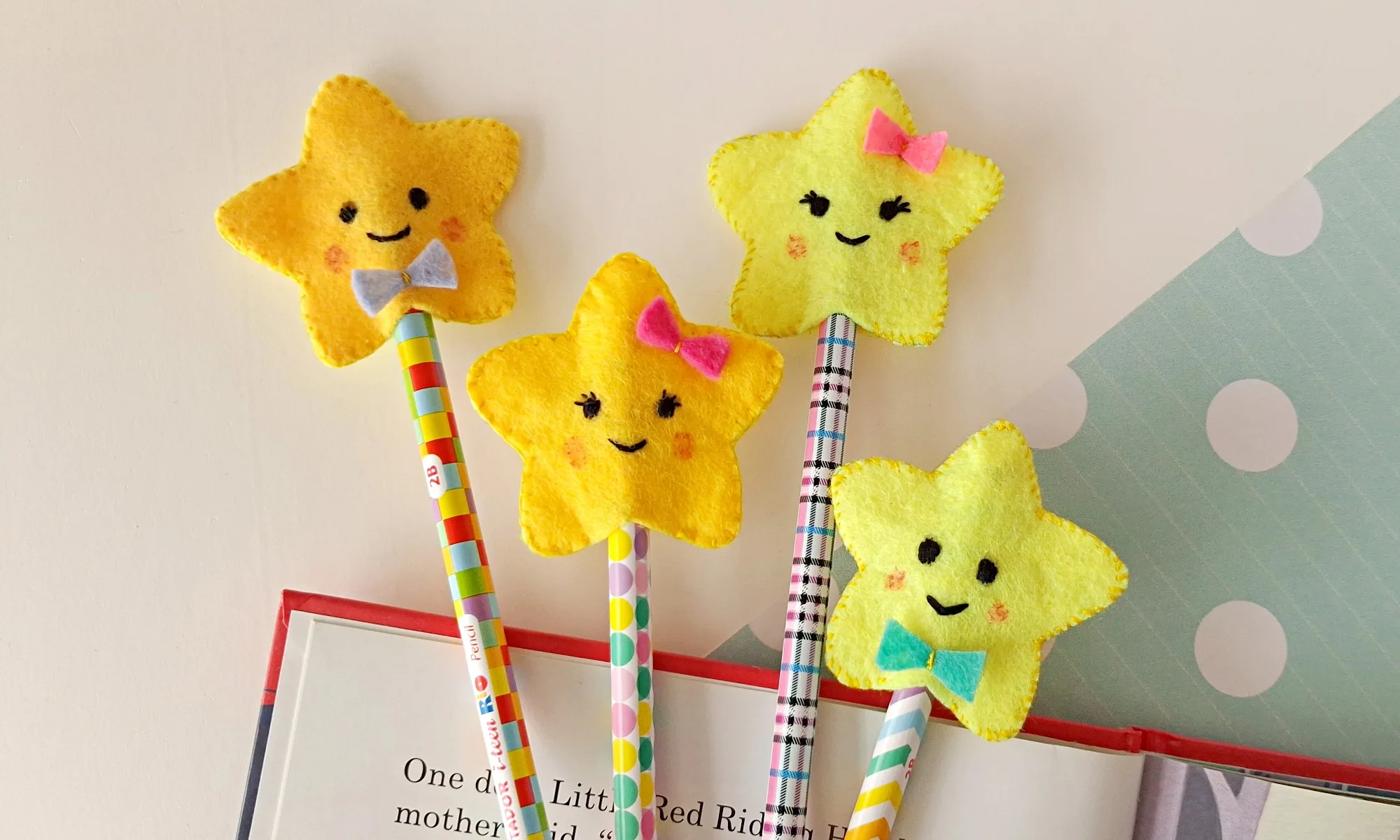 Four finished felt star pencil toppers with bows, on pencils