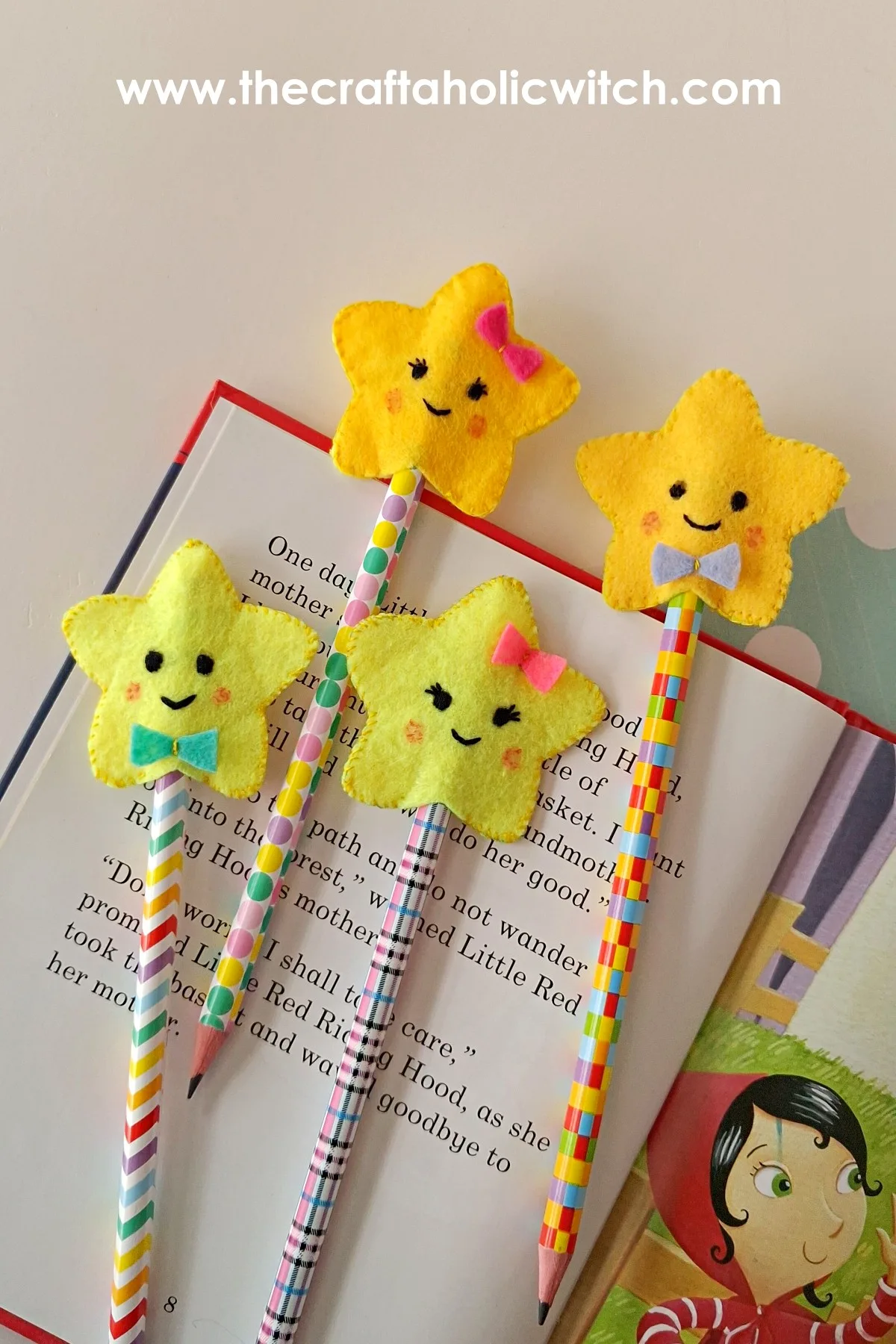Felt star pencil toppers with bows propped in a storybook