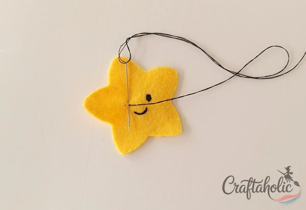 Stitching the eyes and mouth onto the felt star face