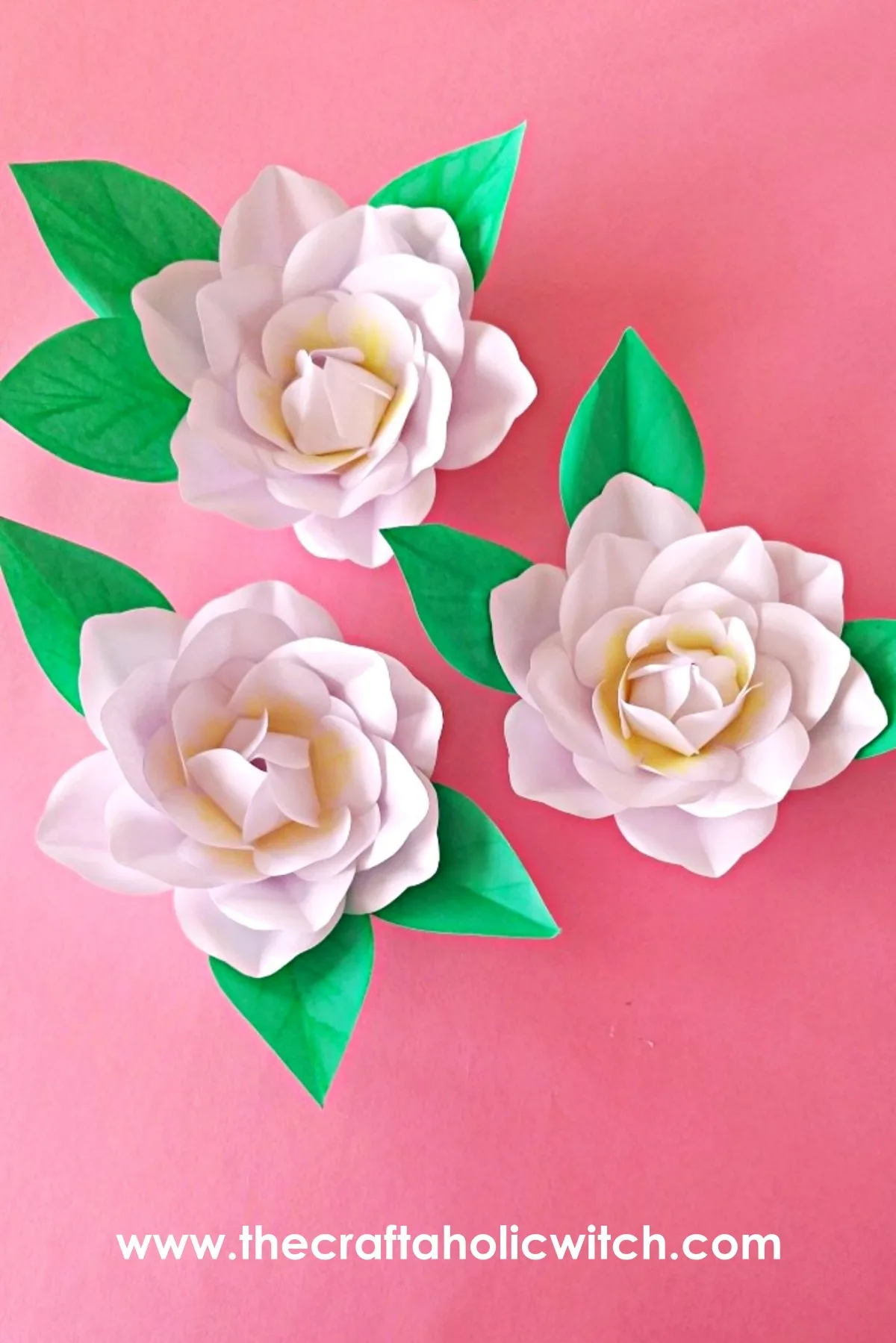 How to Make a Realistic Paper Gardenia Flower 23 Pinnable image of three handmade realistic paper gardenia flowers with craft paper leaves