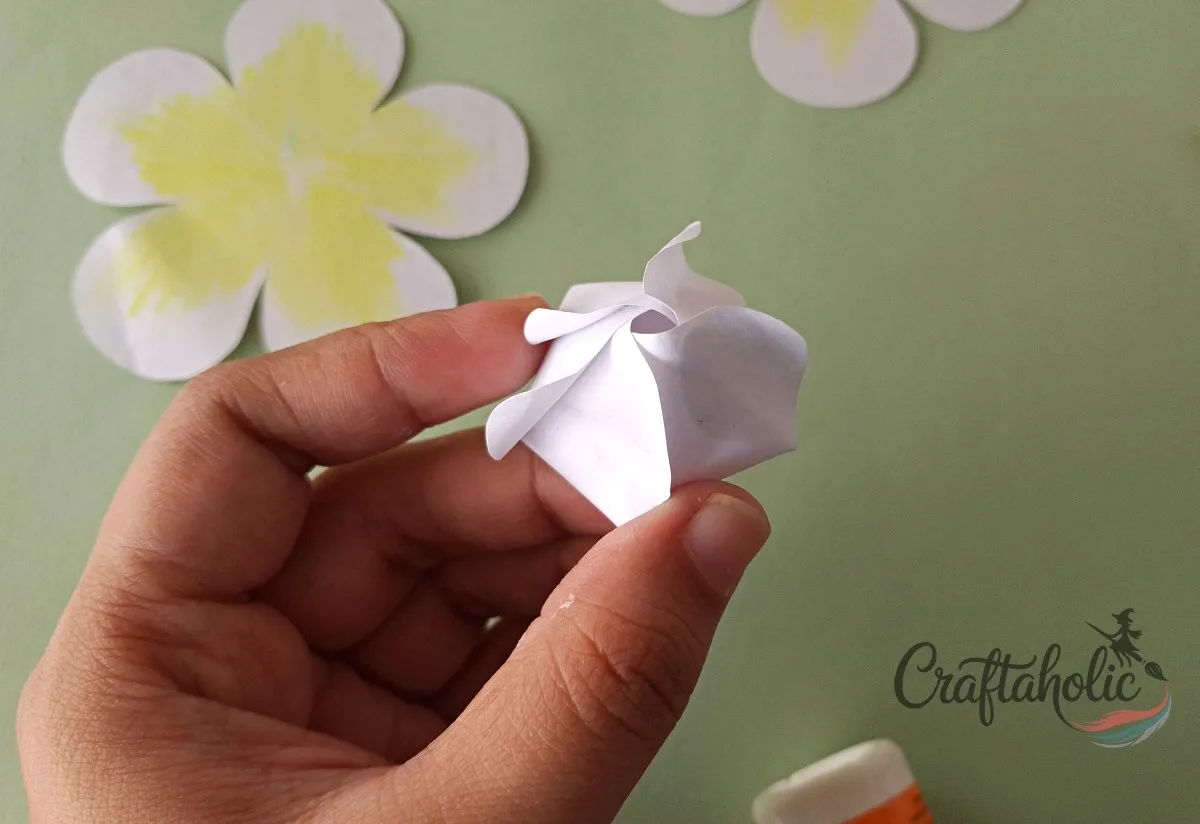 How to Make a Realistic Paper Gardenia Flower 11 Tucking the fifth paper gardenia petal under the first to close the spiral