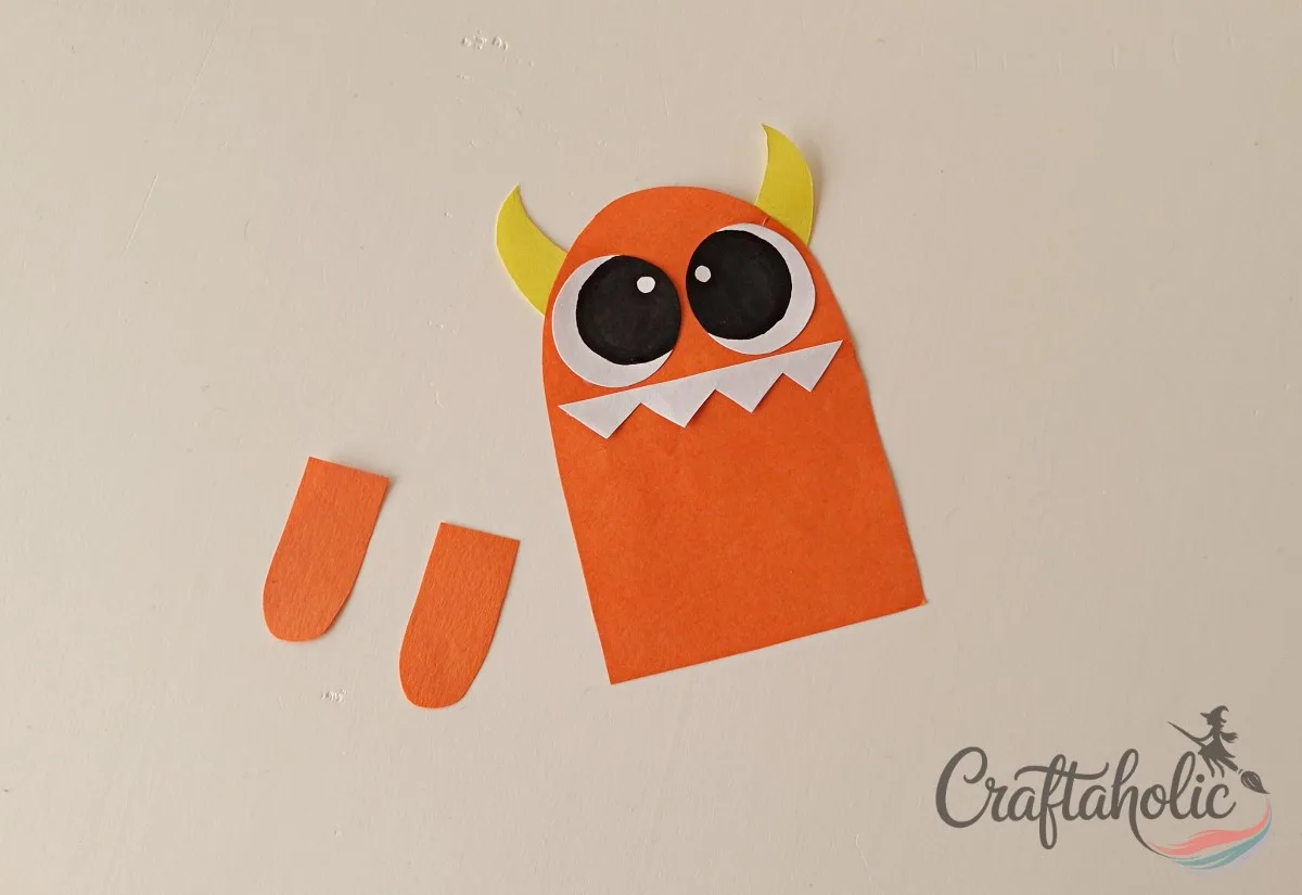 DIY Monster Bookmarks (Easy Paper Craft for Kids) 6 Gluing the eyes above the teeth on the paper monster bookmark