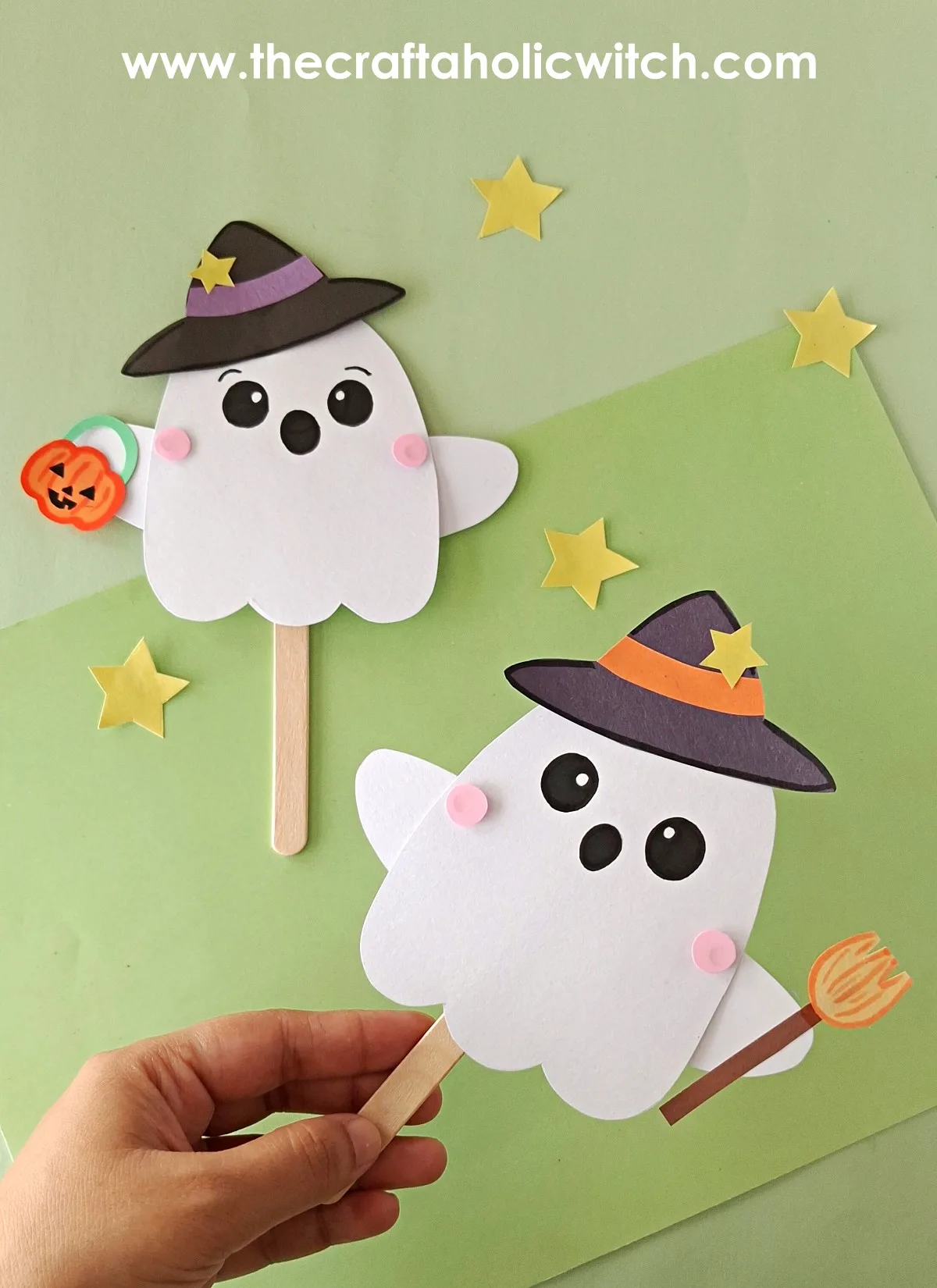Moving ghost puppet held by the handle Two finished moving ghost puppets with witch hats, one held by the popsicle stick handle