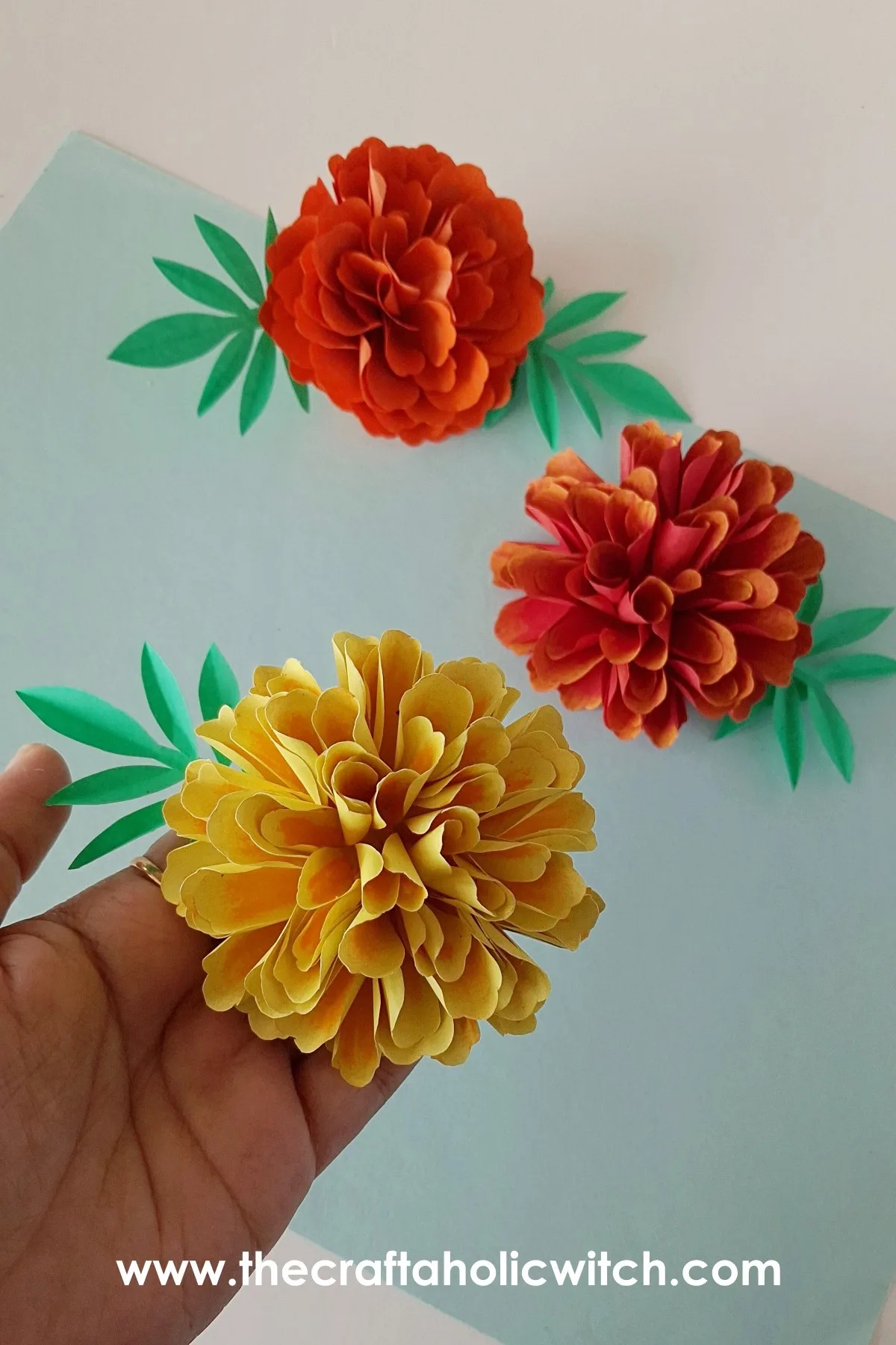 Close-up vertical shot of the realistic paper marigold flower craft