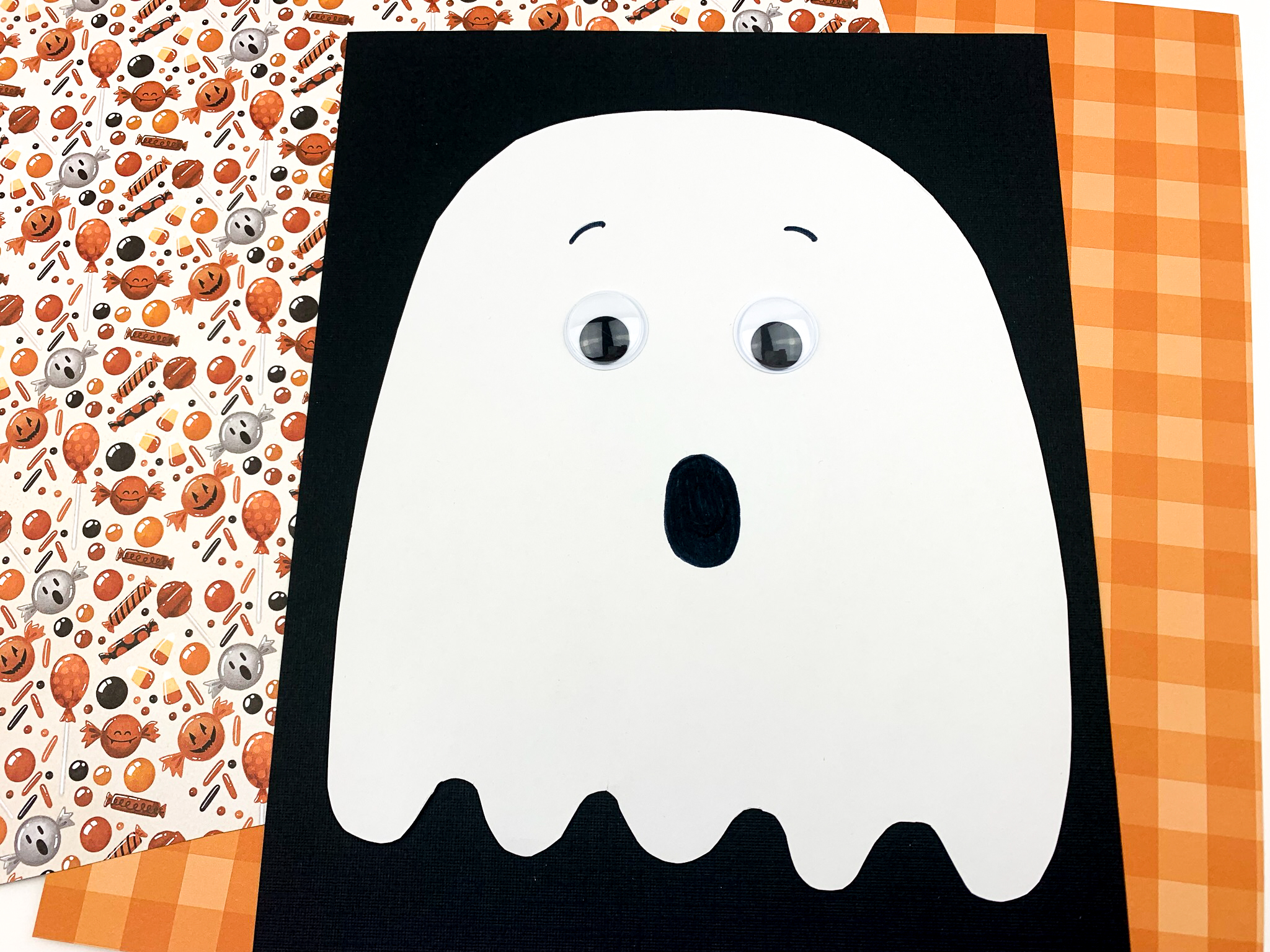 20 Easy Halloween Paper Crafts for Kids to Make at Home 9 Simple paper ghost craft: white paper ghost mounted on black paper for Halloween