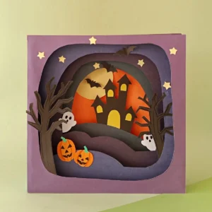 Pinnable vertical photo of the finished 3D Halloween shadow box with a haunted house and glowing moon