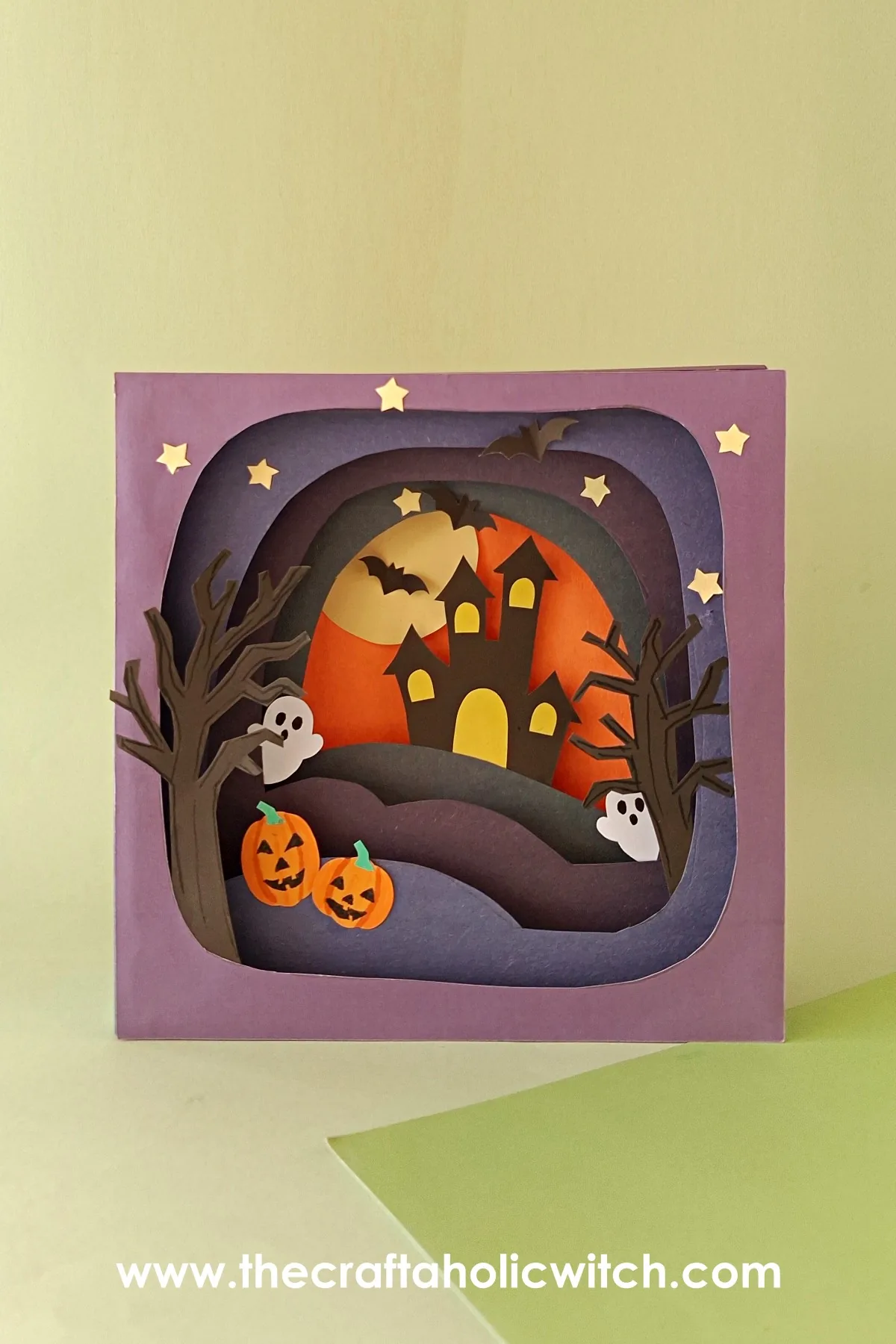 Pinnable photo of the Halloween shadow box Pinnable vertical photo of the finished 3D Halloween shadow box with a haunted house and glowing moon