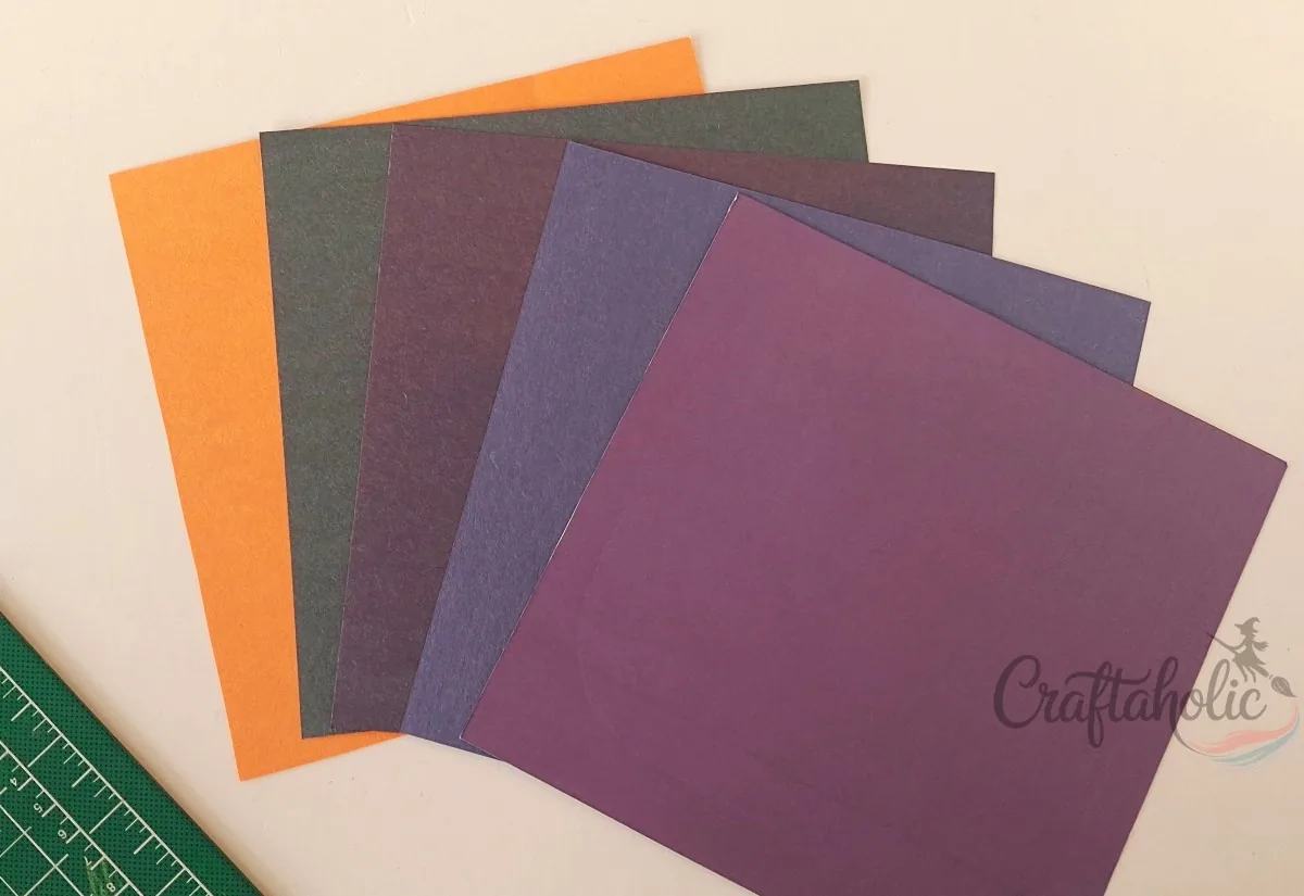 Craft paper for the shadow box layers Five sheets of dark and orange craft paper fanned out for the layers of the 3D Halloween shadow box