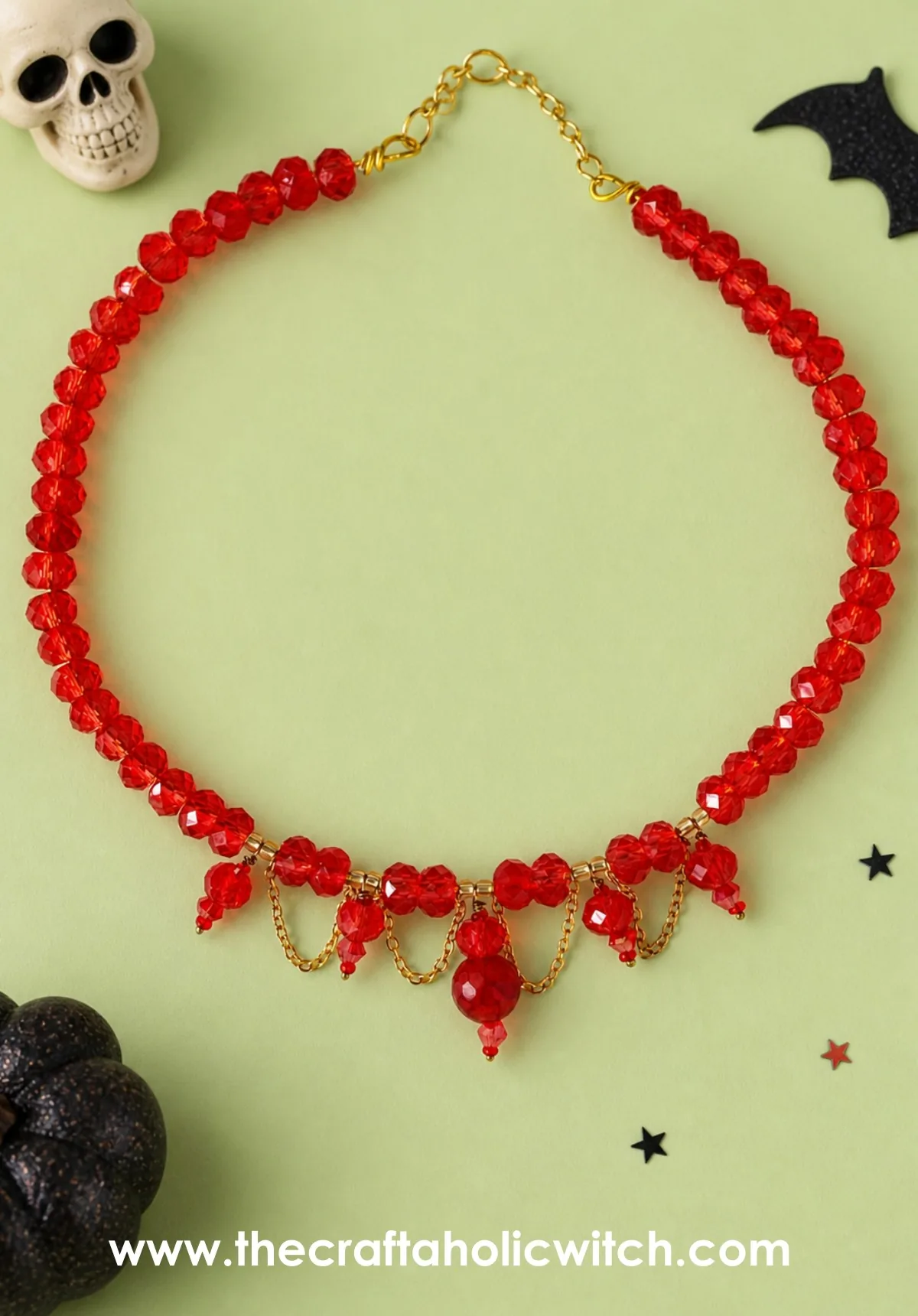 Beaded choker styled with Halloween props Red beaded choker necklace styled with Halloween props on a pastel green background