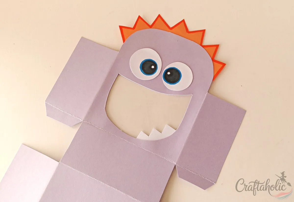 Gluing eyes onto the front of the monster snack box