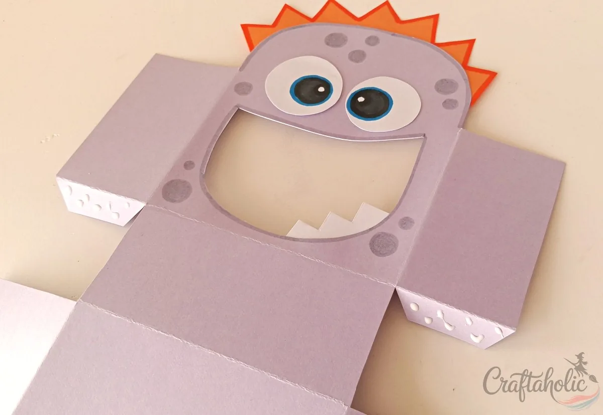 Applying glue to the thin flaps of the monster snack box