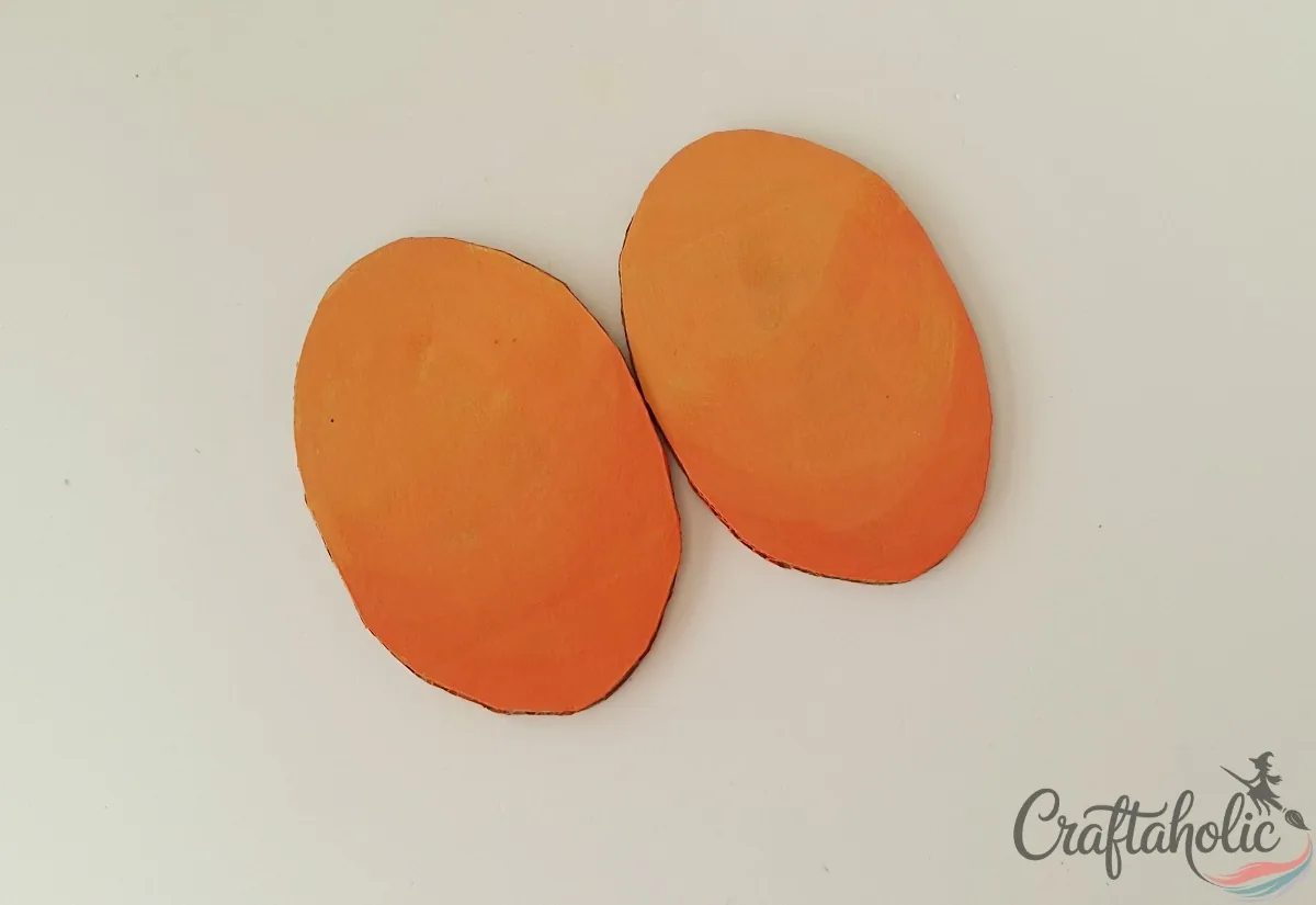 Two plain painted cardboard ovals lying side by side with no gap between them