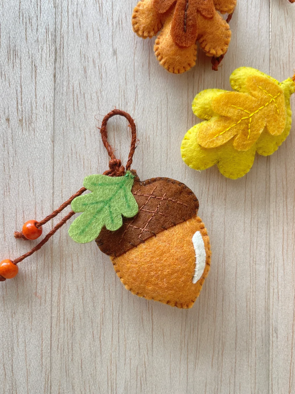 Finished felt acorn ornament Finished felt acorn ornament with a hanging loop and small wooden beads