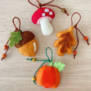 Handmade felt fall ornaments with beaded hanging loops: an acorn, mushroom, leaf and pumpkin