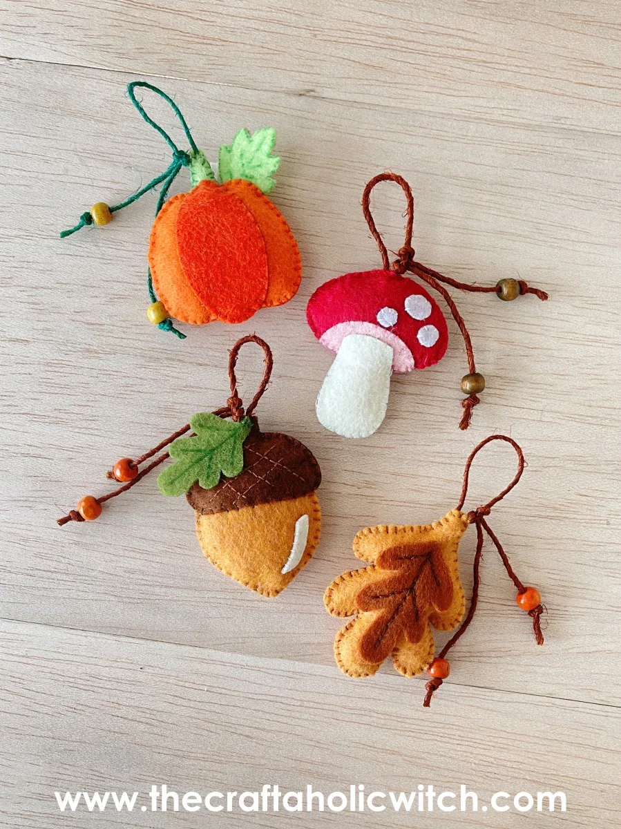 Felt fall ornaments flat lay Flat lay of four handmade felt fall ornaments with beaded string loops: a pumpkin, mushroom, acorn and leaf