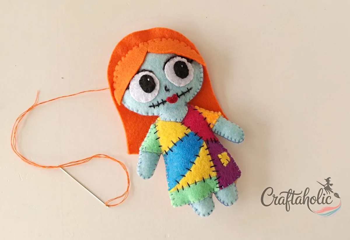 Sally's fringe stitched Fringe cutout stitched to the top of the felt Sally doll face with orange thread