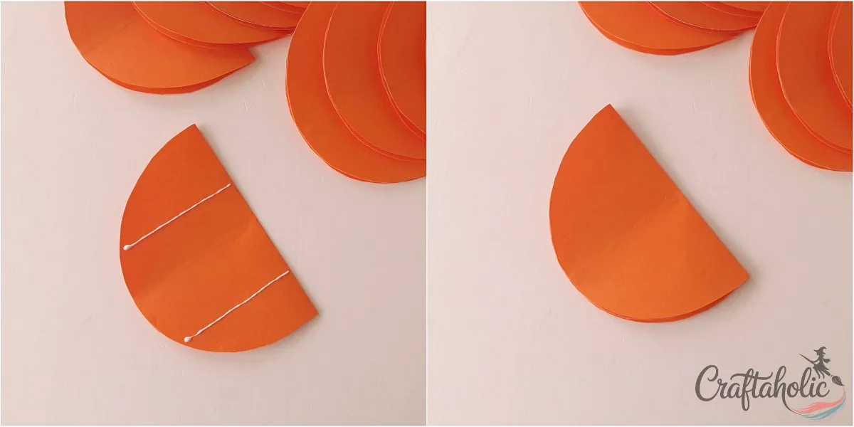 Gluing two lines and stacking 2 lines of glue on a folded orange paper piece, then a second folded piece placed on top